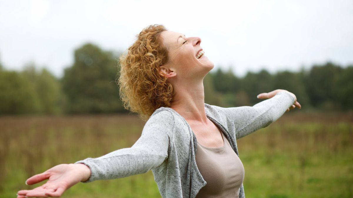 A woman happily feeling the air with both hands wide open