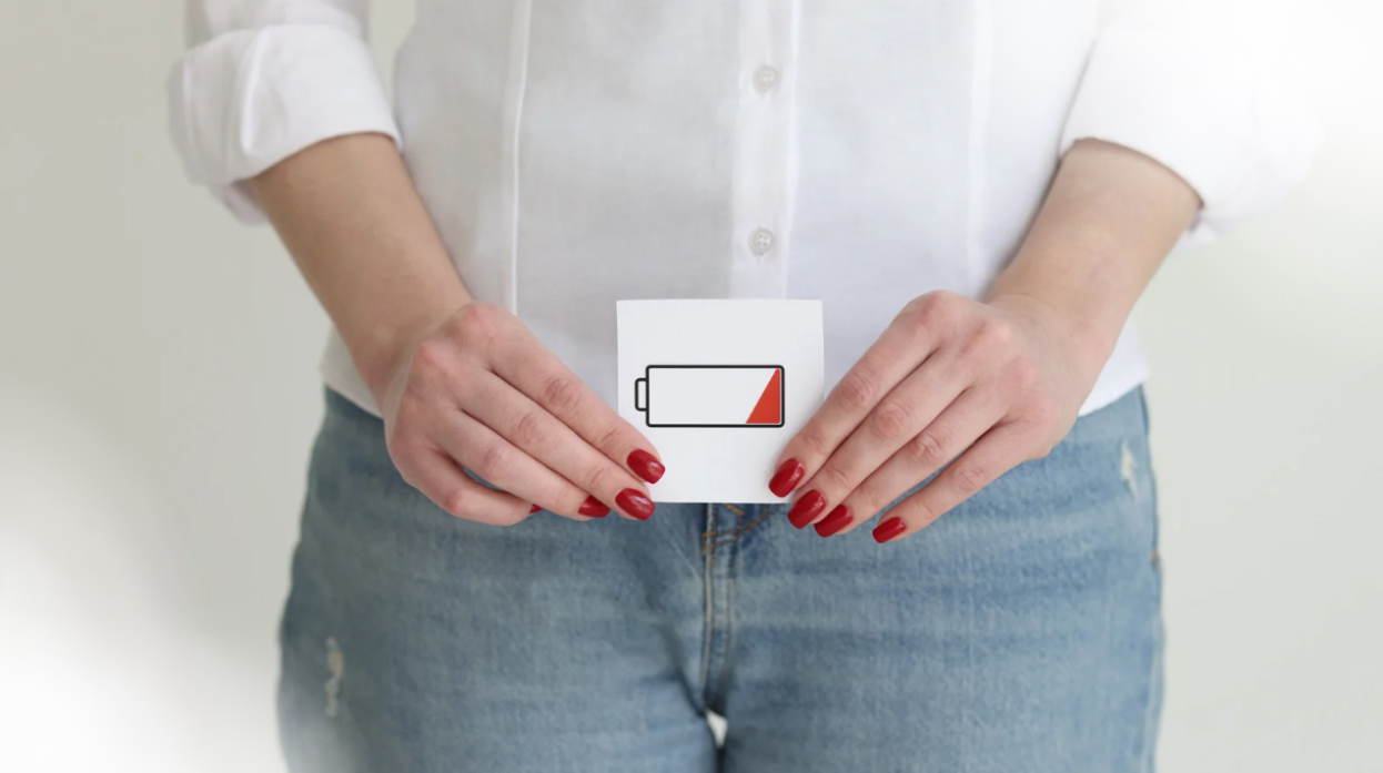 woman holding up a card with a battery low drawing on it